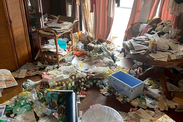 散らかった部屋を清掃する作業員